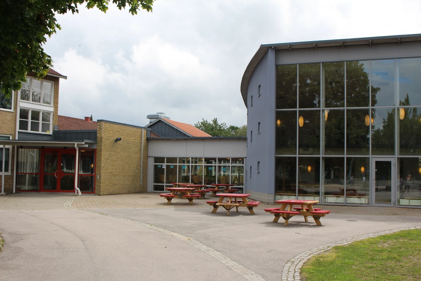 Dackeskolan med asfalterad skolgård med utplacerade bänkar i förgrunden.